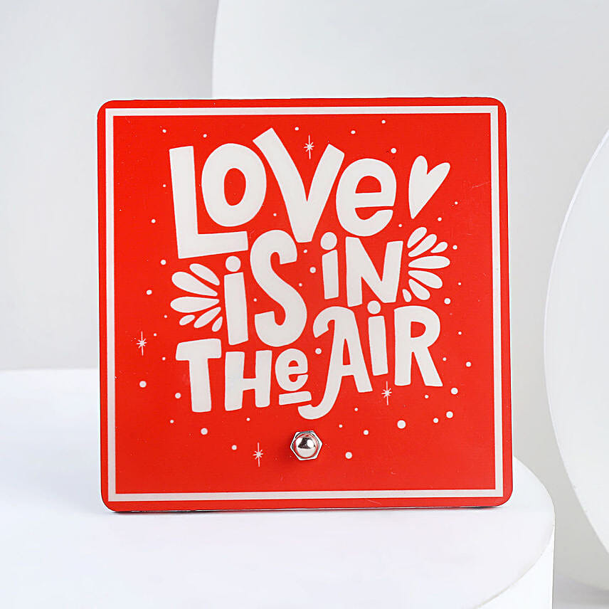 A hamper containing table top, dairy milk , cream teddy bear and a love message gifts