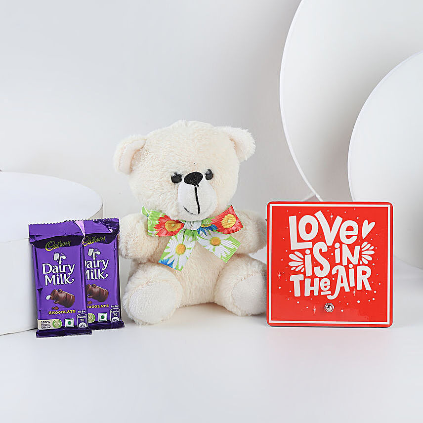 A hamper containing table top, dairy milk , cream teddy bear and a love message gifts:Love N Romance Gifts