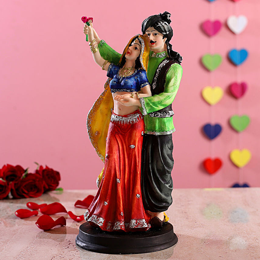 Standing Rajasthani Couple With Rose Figurine:Send Home Decor Gifts