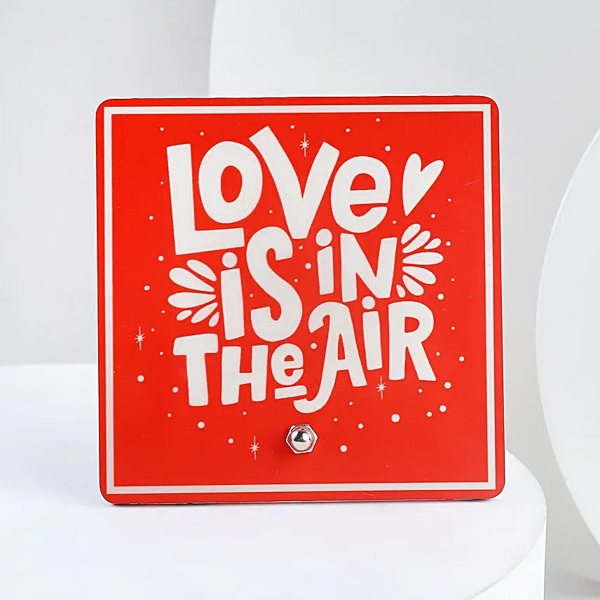 A hamper containing table top, dairy milk , cream teddy bear and a love message gifts