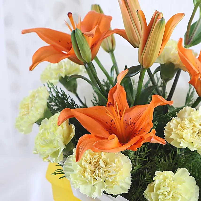 Radiance - Bunch of 10 yellow carnations 2 orange lilies in paper packing.