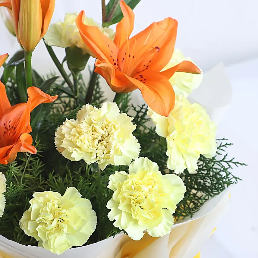 Radiance - Bunch of 10 yellow carnations 2 orange lilies in paper packing.