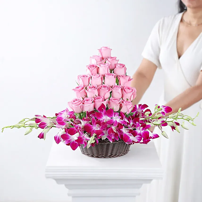Cane Basket arrangement of 20 pink roses and 6 purple orchids