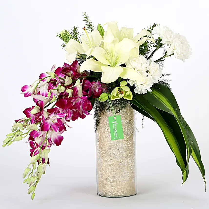 Combo of a glass vase arrangement of 6 purple orchids, 3 white asiatic lilies, 6 white carnations, draceane leaves and vase filler, with 16 pieces of ferrero rocher chocolates