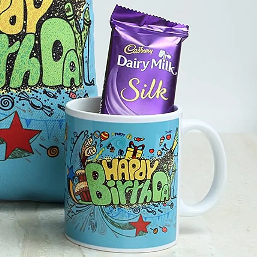 A hamper of cushion, cadbury dairy milk silk chocolate and white coffee mug