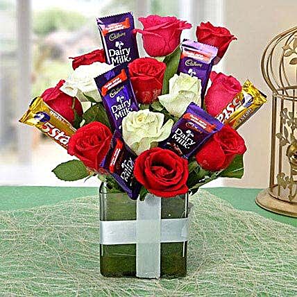 Glass vase arrangement of roses and chocolates