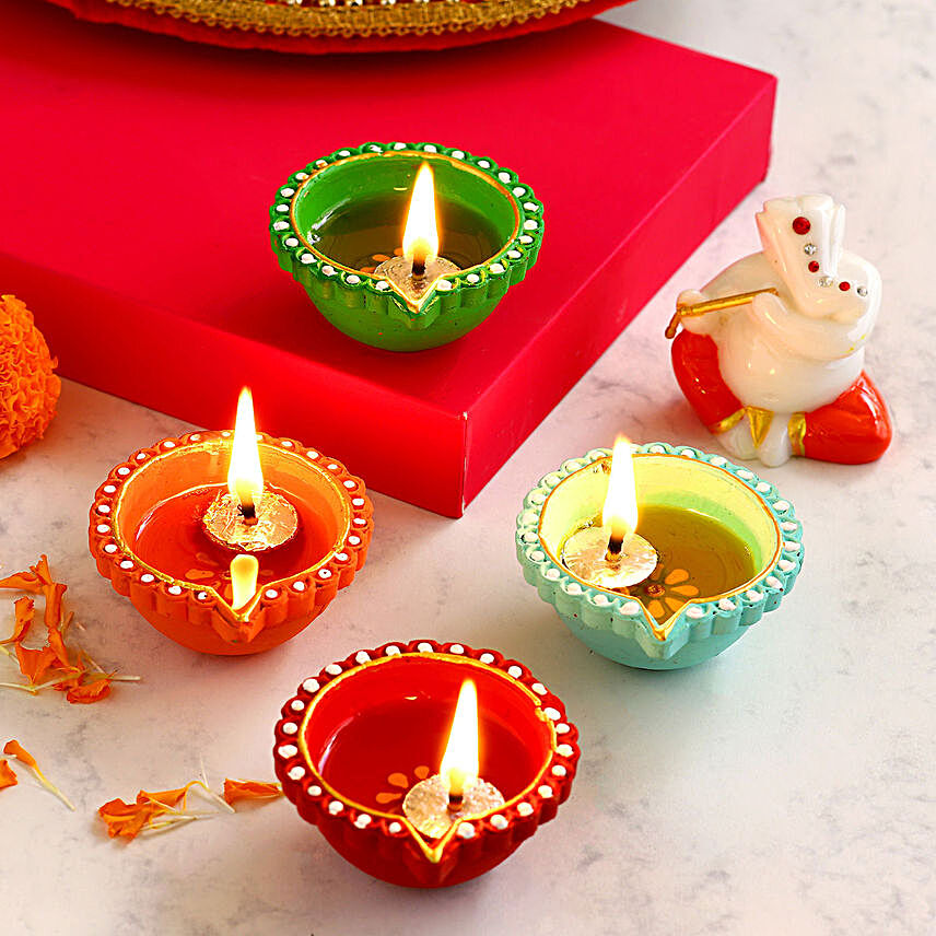 4 Colourful Diyas With Orange and White Ganesha Idol