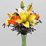 Mixed Asiatic Lilies In Green Glass Vase