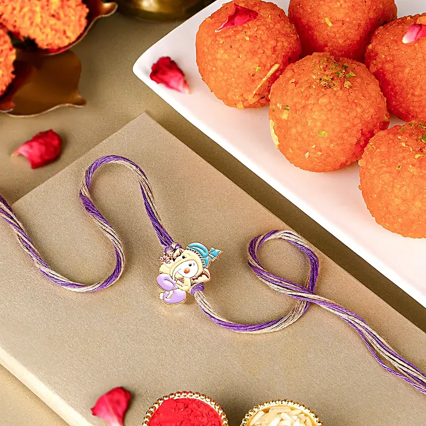 Bal Ganesha Cheerful Charm Rakhi N Laddoo Combo